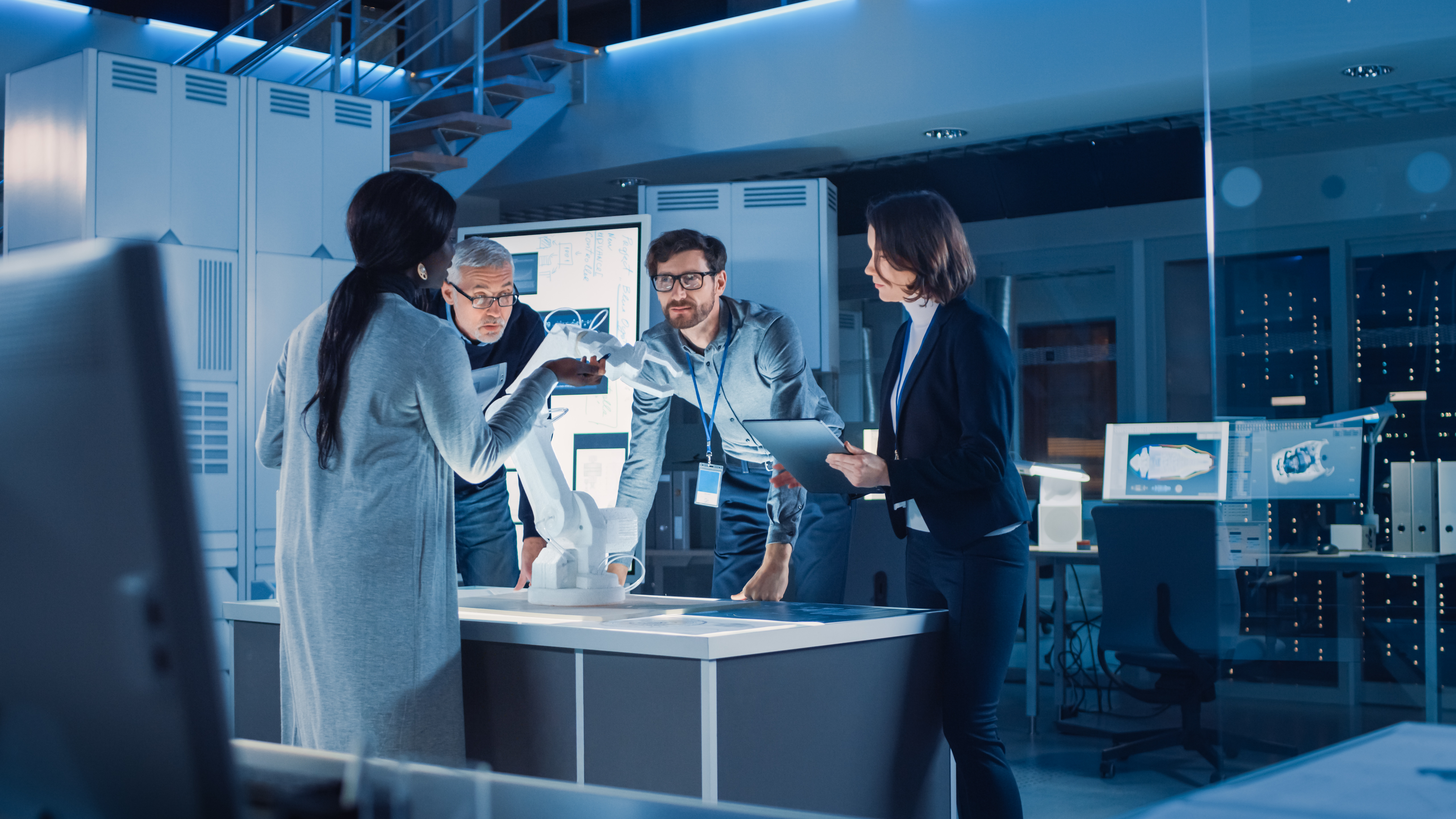 Team von Robotikexperten diskutieren einen Prototyp in einem Werkstattraum