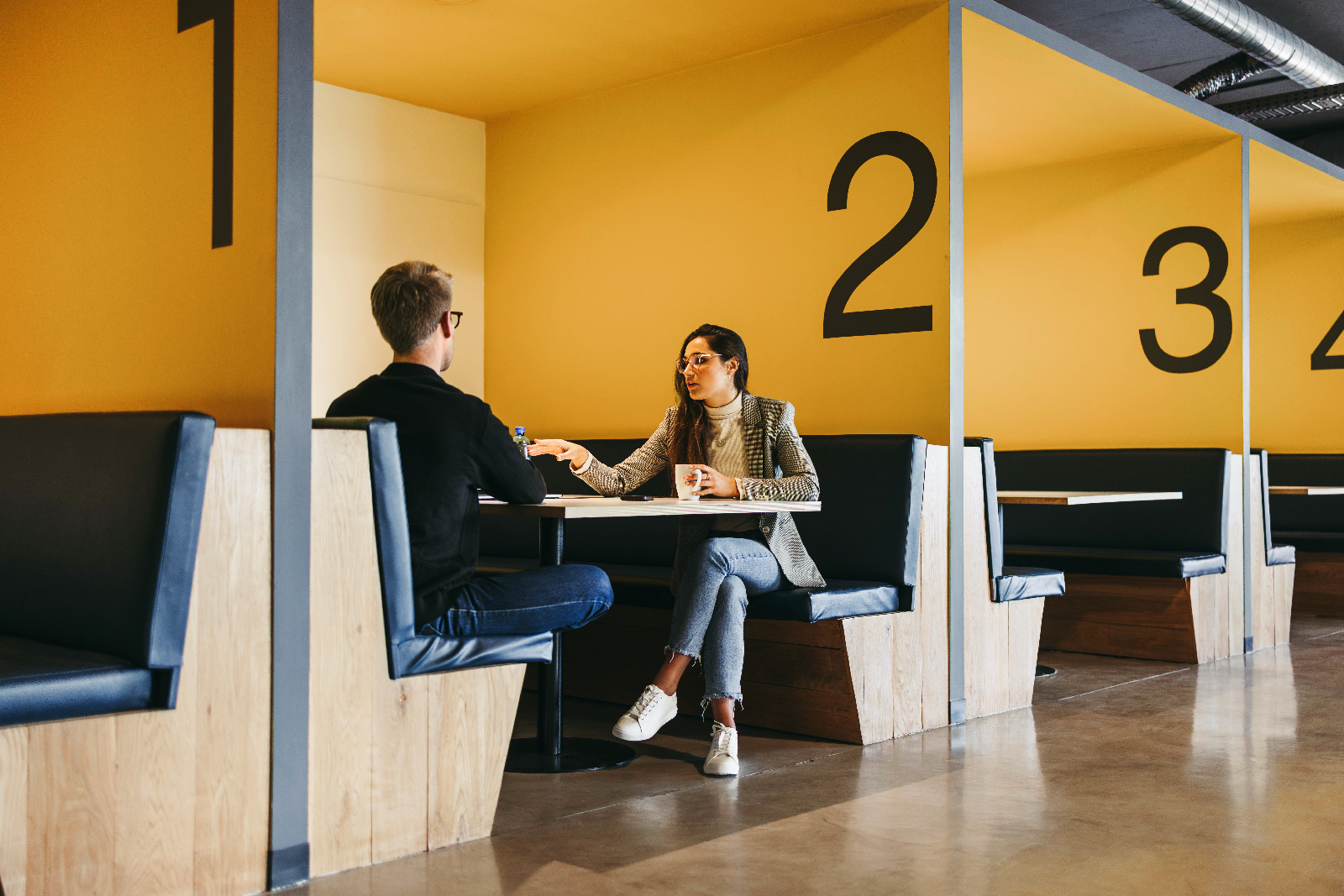 Zwei Entwickler besprechen eine Projektplan in einem Meeting Space eines modernen B&uuml;ros