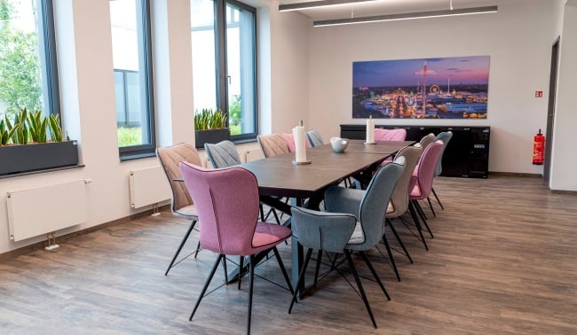 Meetingraum mit Tisch und Stuehlen